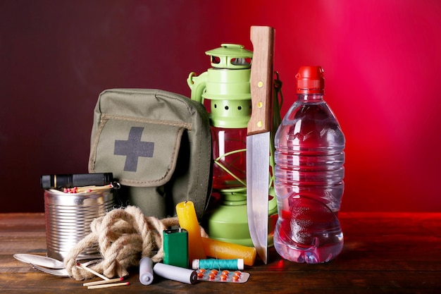 An emergency preparedness kit with essential supplies like water bottles, non-perishable food, a first-aid kit, a flashlight, and a portable radio, all neatly organized in a sturdy container.